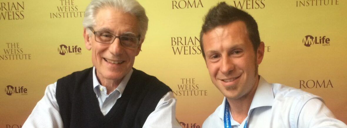 Emilio Borroni e Brian Weiss seduti uno di fianco all'altro guardano sorridenti verso l'obiettivo.